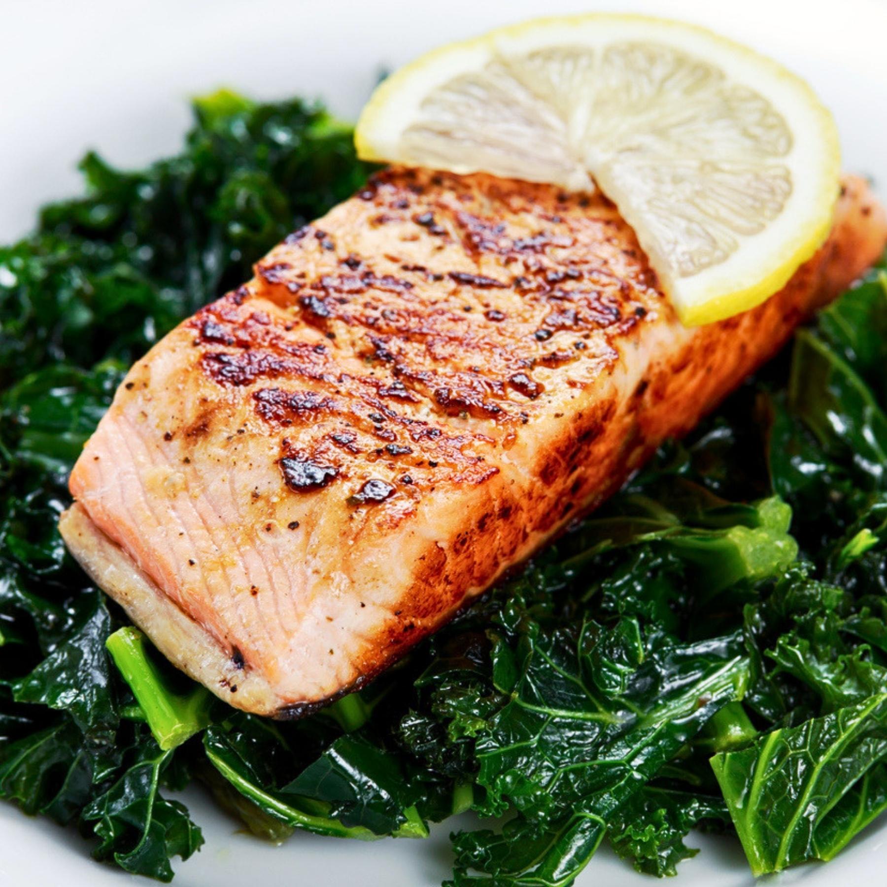 Cooked wild Alaska sockeye salmon served over local kale with lemon