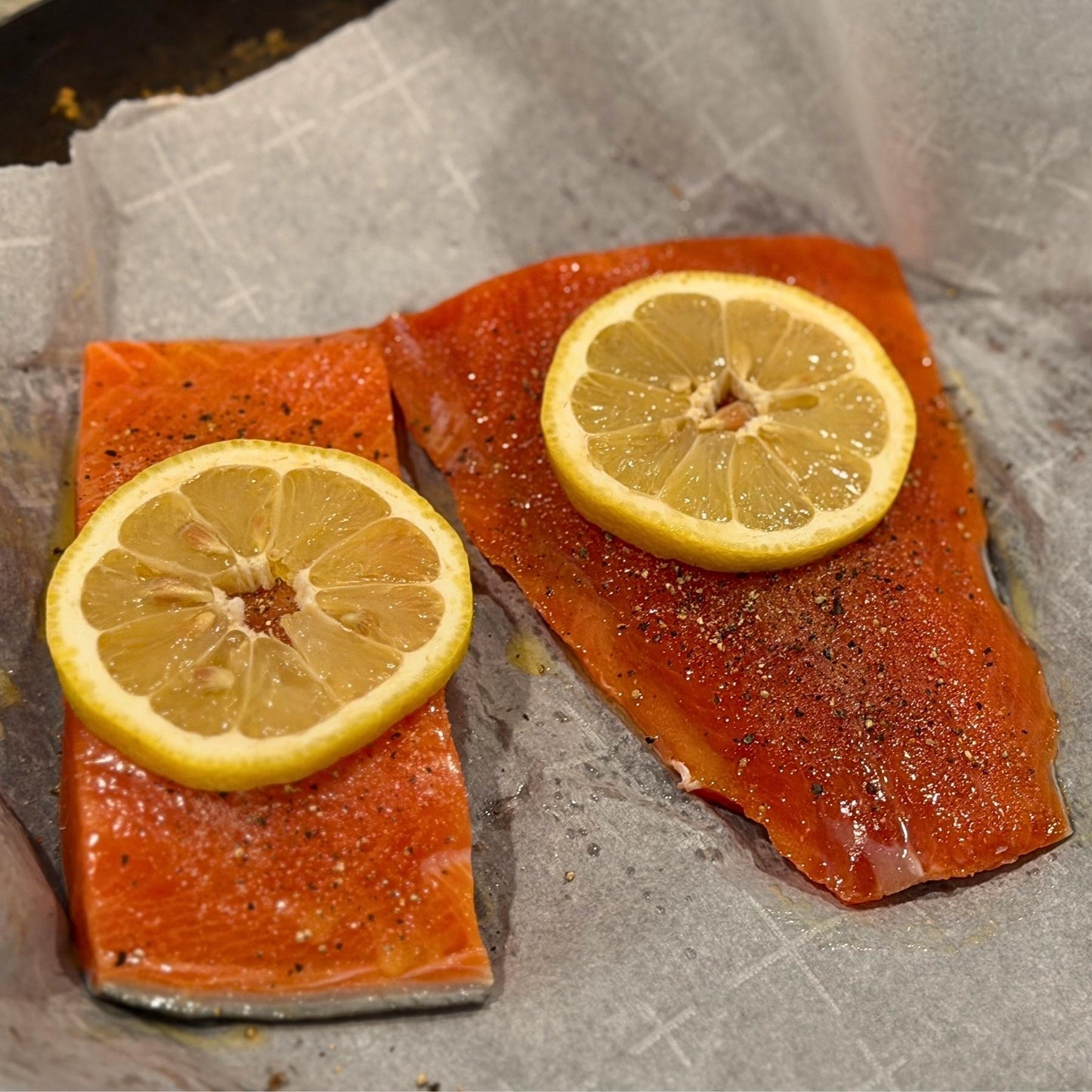 Wild Alaska sockeye salmon portions with lemon ready to cook in a pan